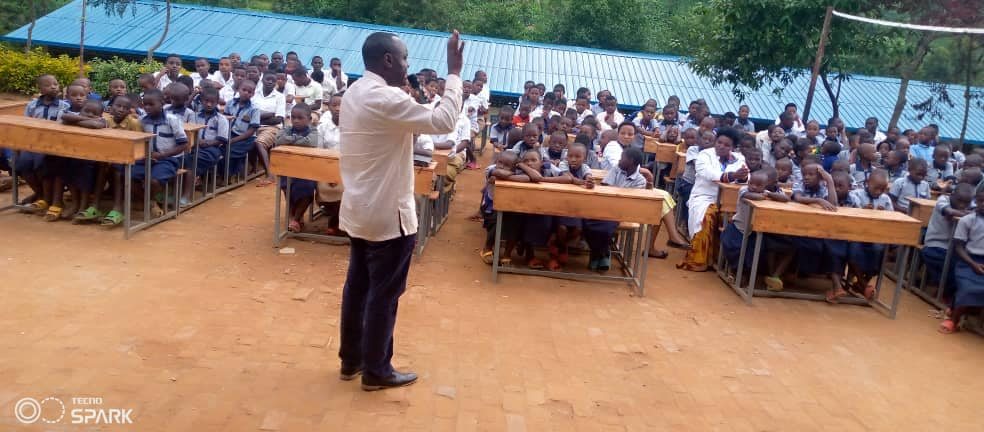 Pastor Fidele speaking to students at a school visit