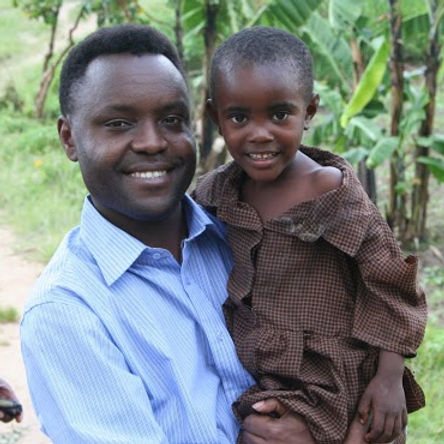 Le pasteur Fidele Bolton portant une fillette au Rwanda